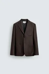 Blazer de corte regular fit confeccionada en tejido de lana italiana. Presenta cuello con solapas de muesca, cierre frontal de un botón, bolsillos de plastrón en el pecho y la cadera, y aberturas en la espalda.
