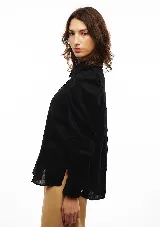 Camisa blanca de lino con cuello clásico, mangas largas con volumen y frunces en los hombros.