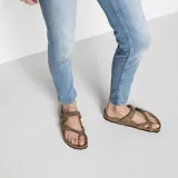 Sandalias Birkenstock Mayari en color marrón tabaco, con diseño de tiras cruzadas y separación para el dedo, equipadas con dos hebillas metálicas ajustables. Cuentan con plantilla anatómica de corcho y suela de EVA.