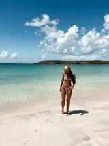 Top de bikini color lila con textura arrugada, corte triangular y tirantes finos regulables.