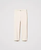 Pantalón de vestir color crema, de corte recto y tiro alto, confeccionado en tejido de punto milano con mezcla de viscosa elástica. Presenta bolsillos laterales inclinados, raya permanente y tira en la cintura con hebilla metálica con logo de la marca. Cierre lateral con cremallera.