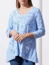 Blusa de algodón labrado marca Ruby Rd, con estampado abstracto en blanco y celeste, escote en V, mangas tres cuartos y aplique de botones en los laterales. Corte asimétrico.