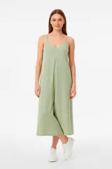 Mono de lino color verde claro, con breteles finos, cuello en V y diseño holgado de pierna ancha.