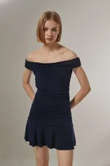 Vestido corto azul marino con diseño strapless y escote con solapa drapeada. Presenta un cuerpo ajustado con frunces laterales y una falda con volados en el ruedo.