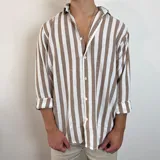 Camisa de lino de corte oversize con diseño de rayas verticales en tonos blanco y tostado, manga larga y cierre frontal con botones.