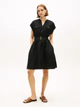 Vestido camisero corto negro confeccionado en mezcla de lino y viscosa, con cuello en V, manga tipo kimono, bolsillos con solapa en el pecho y cintura fruncida con cinturón incorporado con hebilla dorada.