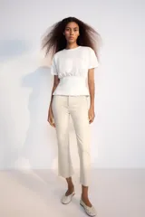 Jeans de tiro alto con cinco bolsillos, diseño cropped flare y bajo sin costuras. Cuenta con cierre frontal de cremallera y botón metálico.