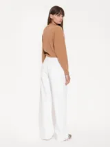 Pantalón de jean blanco, corte wide leg, con detalles de recortes y remaches tipo carpintero.