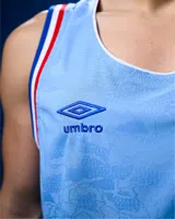 Camiseta de básquet Umbro de edición especial del Club Nacional de Football, color celeste con detalles en azul, blanco y rojo en el cuello y las sisas. Presenta el logo de Umbro y el escudo del club bordados en el pecho.