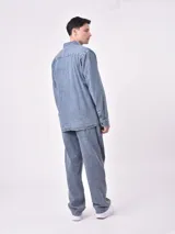 Sobrecamisa de jean celeste con dos bolsillos frontales con solapa y cierre con botones.