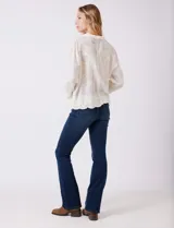 Camisa de algodón color gris con bordados florales en el frente y las mangas. Tiene cuello con solapa y cierre frontal con botones.