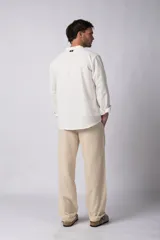 Camisa de manga larga color blanco roto, confeccionada en una mezcla de lino y viscosa, con cuello mao y corte relajado.