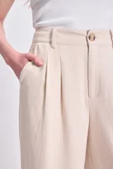 Pantalón de lino color crudo, de corte palazzo y tiro alto.