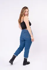 Pantalón tipo mom jean de tiro alto en color azul medio, con costuras en tono dorado y corte cónico.