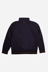 Campera de nylon azul marino, resistente y liviana, con cuello y cintura en rib marrón. Presenta logo en grifa de goma y puños con rib a tono.