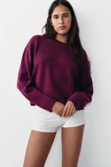 Jersey de punto con cuello redondo y manga larga, confeccionado en un suave tejido color bordó.