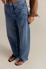Jean de tiro medio color azul con diseño baggy, pernera curva y cierre frontal de botón.