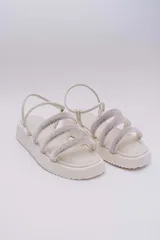 Sandalias bajas color crema con plataforma y tres tiras horizontales con strass.