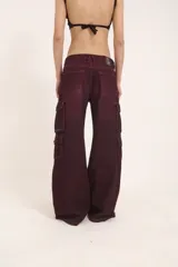 Pantalón jean cargo color borgoña, de pierna ancha y tiro medio, con múltiples bolsillos con solapa y broches.