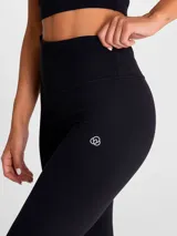 Calza deportiva de tiro alto y largo hasta el tobillo, en color negro. Diseño liso sin bolsillos, confeccionada en tejido técnico de alta calidad.