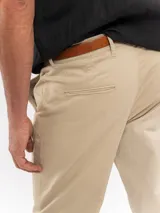 Pantalón chino de corte regular y tiro medio, color azul marino, con cierre de botón y cremallera, bolsillos laterales y traseros, y terminación recta.