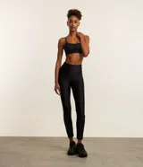 Calza deportiva negra de microfibra con detalle texturizado en la parte inferior de las piernas.