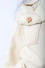 Vestido camisero corto de denim azul oscuro, con cuello clásico, mangas 3/4 con puños abotonados, cierre frontal con botones color cobre, cinturón de lazo y bolsillos con solapa en el pecho.