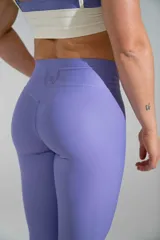 Calza deportiva larga de tiro alto en color lila, confeccionada en poliamida con elastano, diseñada para brindar confort y ajuste durante el entrenamiento.