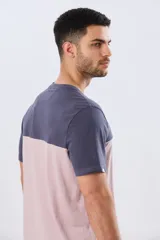 Remera de algodón y poliéster de corte clásico, con diseño en bloques de color negro en la parte superior y gris melange en la inferior. Presenta cuello redondo, mangas cortas y un pequeño estampado tipográfico en el pecho.