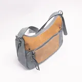 Bandolera de cuero sintético en color celeste con detalles y bolsillo frontal en tono tostado, decorada con tachas metálicas plateadas y cierre superior con cremallera.