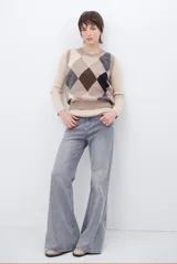 Chaleco de punto con diseño de rombos en tonos beige, marrón y gris. Presenta cuello redondo y corte ajustado a la cintura.