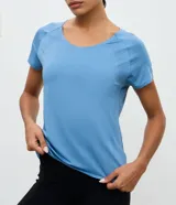 Remera deportiva de microfibra color blanco, con cuello redondo, mangas cortas y paneles laterales con textura perforada para mayor ventilación.