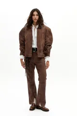 Pantalón de cuero de oveja color marrón antiguo, de corte recto, tiro medio, con elástico interno en la cintura y tajos en el ruedo.