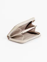 Billetera compacta de cuero plateado, con cierre perimetral y logo grabado en el frente.
