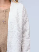 Cardigan largo color verde oliva con textura labrada, abertura central y bolsillos delanteros.