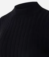 Blusa de punto canalé color negro, con cuello alto, manga larga y diseño ajustado con dobladillo estilo peplum.
