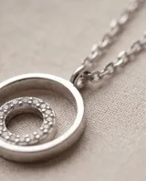 Collar de plata con cadena fina y dije colgante de doble círculo, con un círculo interior pavé de circonias.