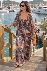 Conjunto de tres piezas estampado con patrón geométrico y floral en tonos beige, negro y blanco, compuesto por un top strapless con fruncido elástico, un pantalón ancho de tiro alto y un kimono largo de mangas amplias.