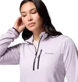 Buzo tipo polar de mujer con cierre de media cremallera, cuello alto y bolsillo frontal con cierre en el pecho. Presenta tecnología de absorción de humedad y ribetes en puños y cuello.