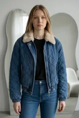 Campera de jean azul con diseño acolchado en forma de rombos, cuello de piel sintética en tono beige, cierre frontal con cremallera y puños elásticos.