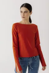 Remera de manga larga color naranja, con cuello bote y tajo lateral en los puños.