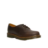 Zapato de tres ojales Dr. Martens modelo 1461, confeccionado en cuero Crazy Horse color marrón con acabado encerado. Presenta costuras amarillas características en el borde de la suela y suela de goma con cámara de aire.
