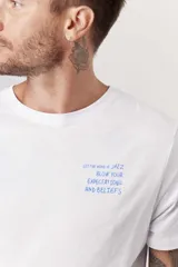 Remera blanca de manga corta con cuello redondo y un pequeño estampado azul en el pecho.