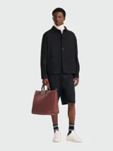 Bolso de viaje grande Longchamp modelo Le Pliage One, confeccionado en lona resistente color bordó con detalles en cuero al tono. Cuenta con cierre superior, asas cortas de mano y solapa frontal con botón a presión.