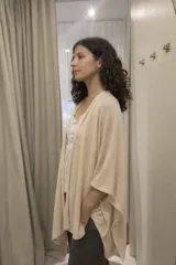 Ruana abierta de tejido liviano con caída fluida y textura sutil, diseñada con un corte amplio y versátil que envuelve el cuerpo.