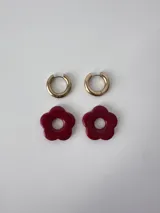Aros de acero quirúrgico dorados con argollas pequeñas y dijes colgantes en forma de flor color celeste.