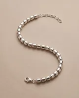 Pulsera de plata 925 compuesta por pequeños cubos facetados en hilo de plata y cadena de alargue finalizada en dije colgante.