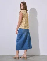 Blusa estampada color amarillo con flores blancas, de corte recto y mangas cortas con volados. Presenta frunces en la parte delantera y abertura con botón en la espalda. Marca Premise.