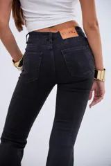 Pantalón de jean estilo oxford en color negro, con tiro medio-alto y costuras verticales frontales que estilizan la silueta.
