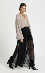 Pantalón de tiro alto confeccionado en tul negro, con silueta ajustada en la cadera y caída fluida. Presenta una cinturilla con detalle de aberturas horizontales y diseño de largo hasta el tobillo.